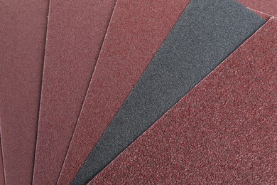 Many sheets of sandpaper as background, top view