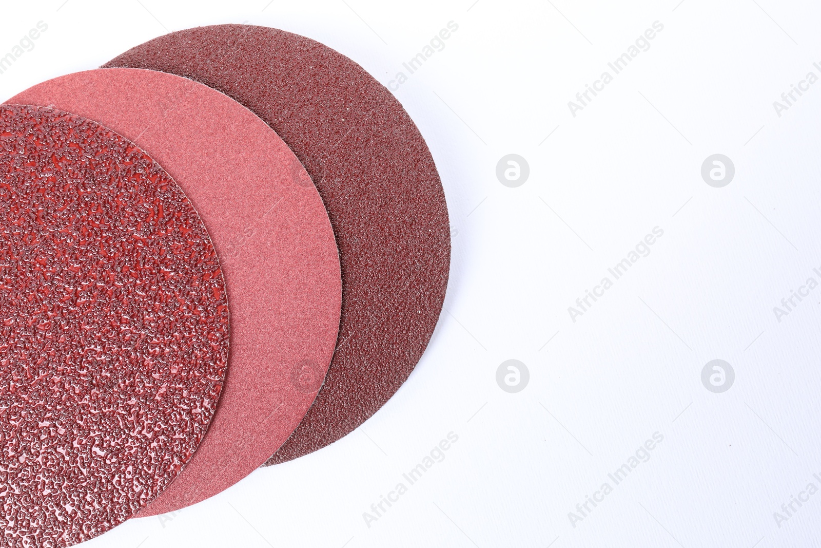 Photo of Coarse sandpaper disks isolated on white, top view