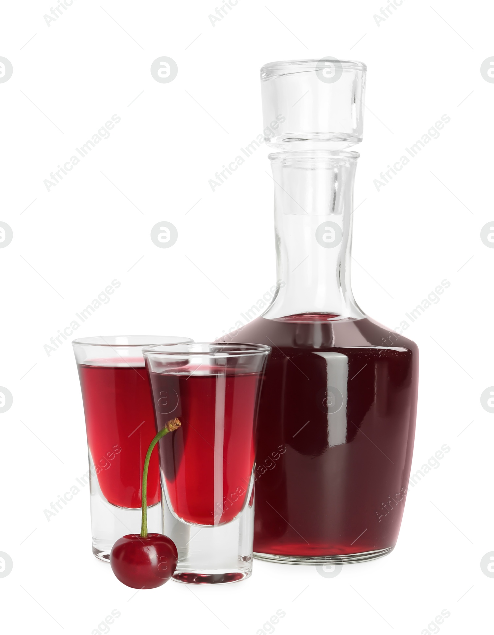 Photo of Bottle and shot glasses of delicious cherry liqueur isolated on white