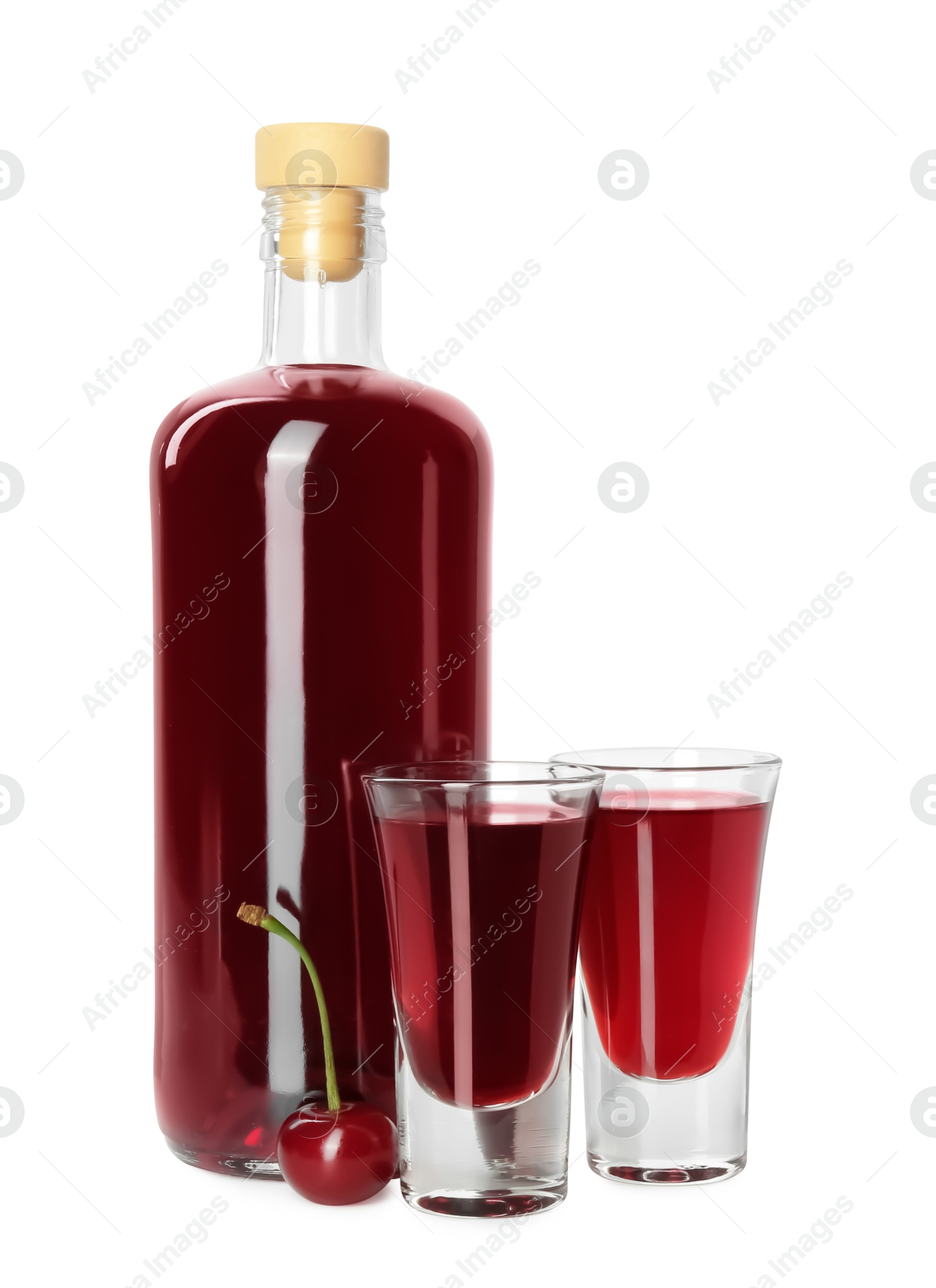 Photo of Bottle and shot glasses of delicious cherry liqueur isolated on white