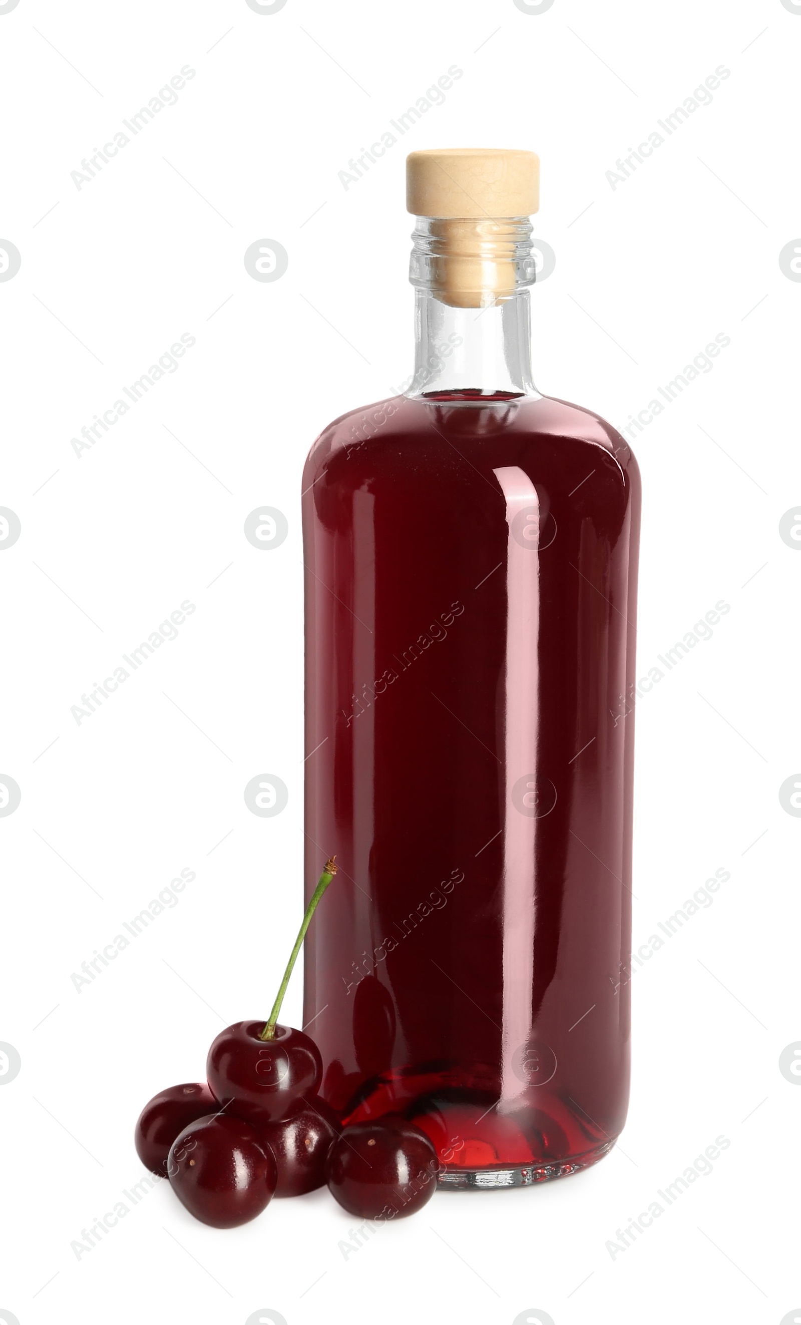 Photo of Delicious cherry liqueur in bottle and berries isolated on white