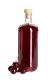 Photo of Delicious cherry liqueur in bottle and berries isolated on white