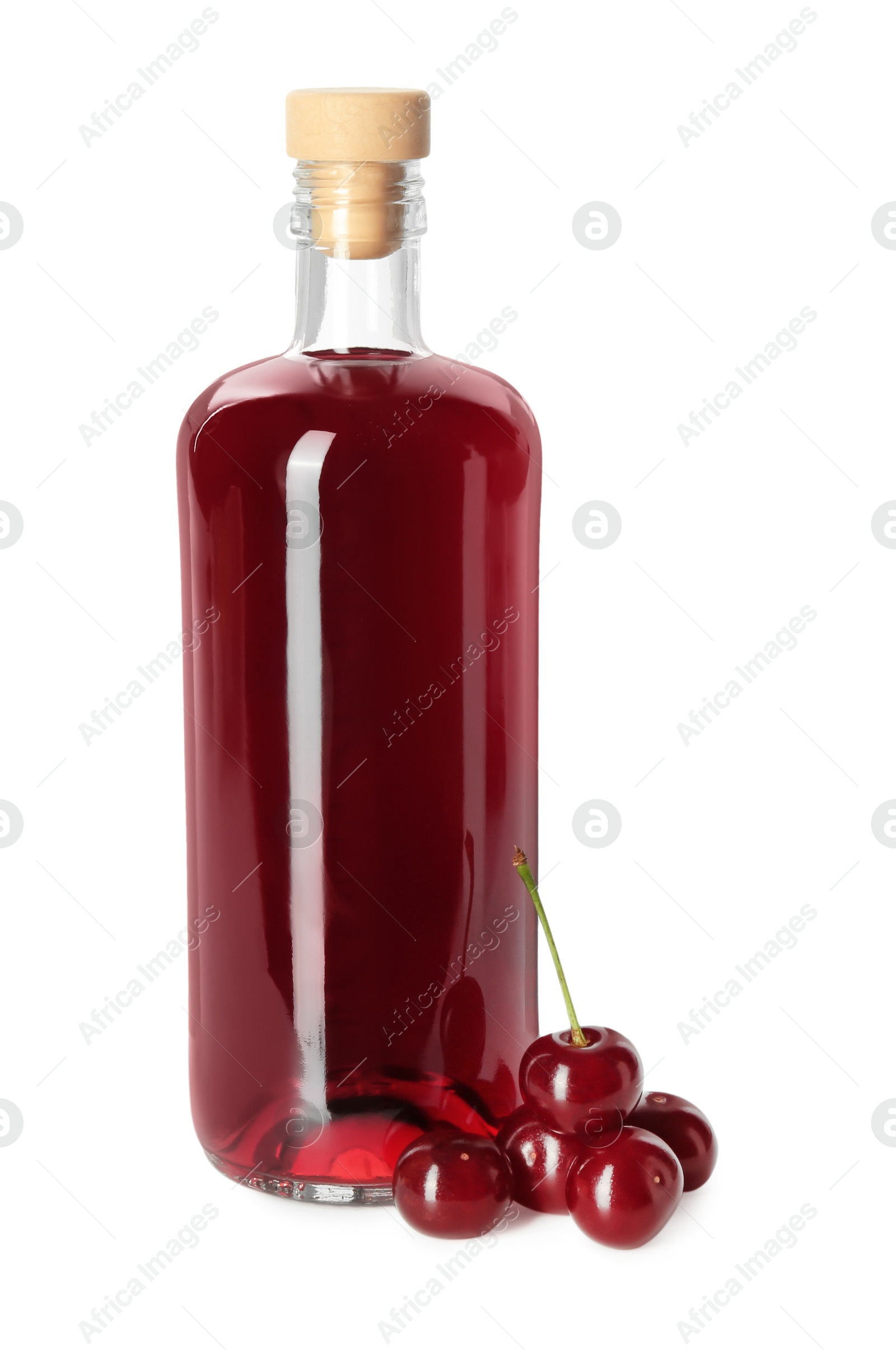 Photo of Delicious cherry liqueur in bottle and berries isolated on white