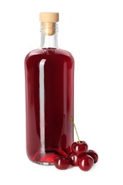 Delicious cherry liqueur in bottle and berries isolated on white