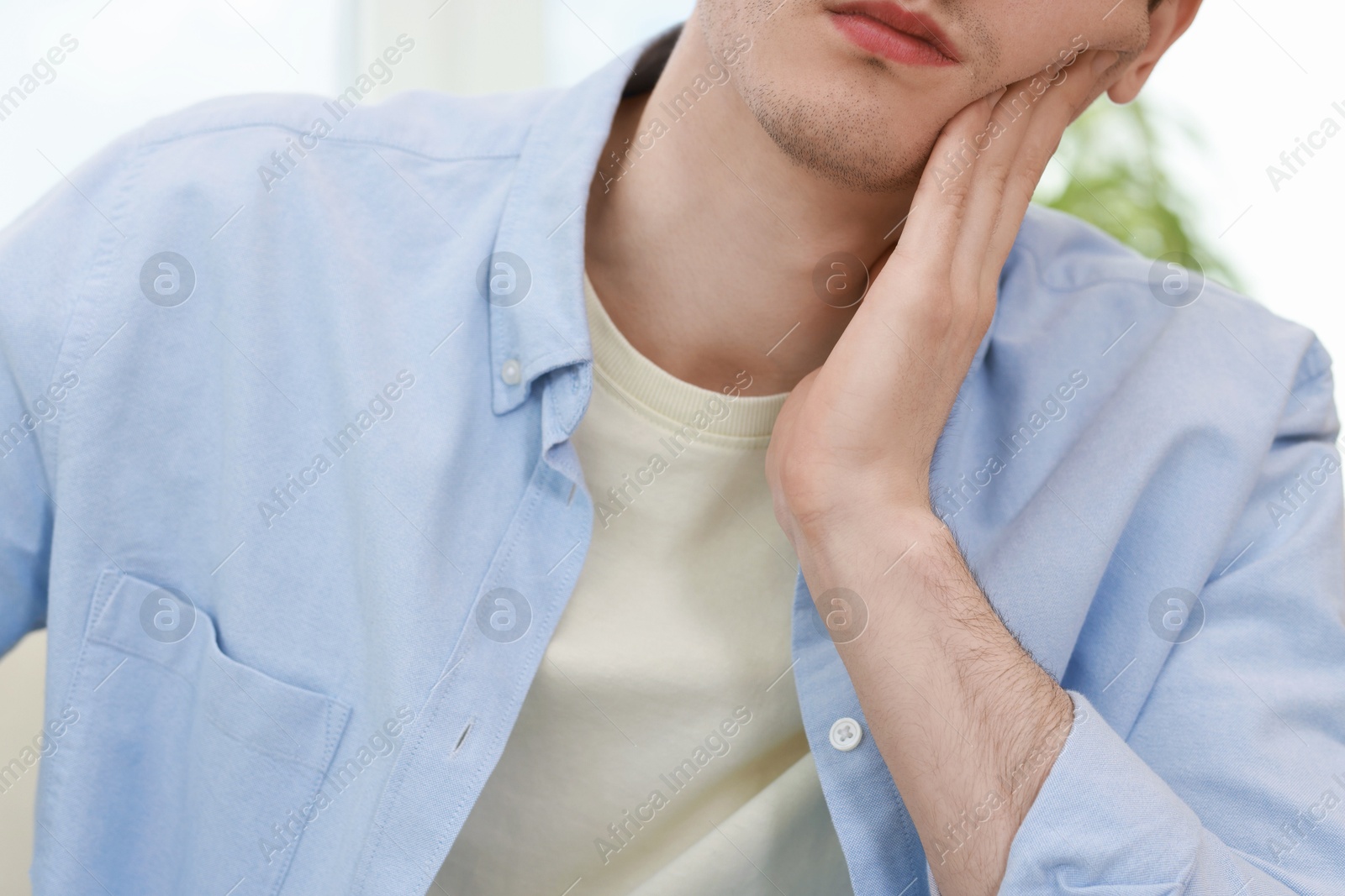 Photo of Man suffering from toothache at home, closeup