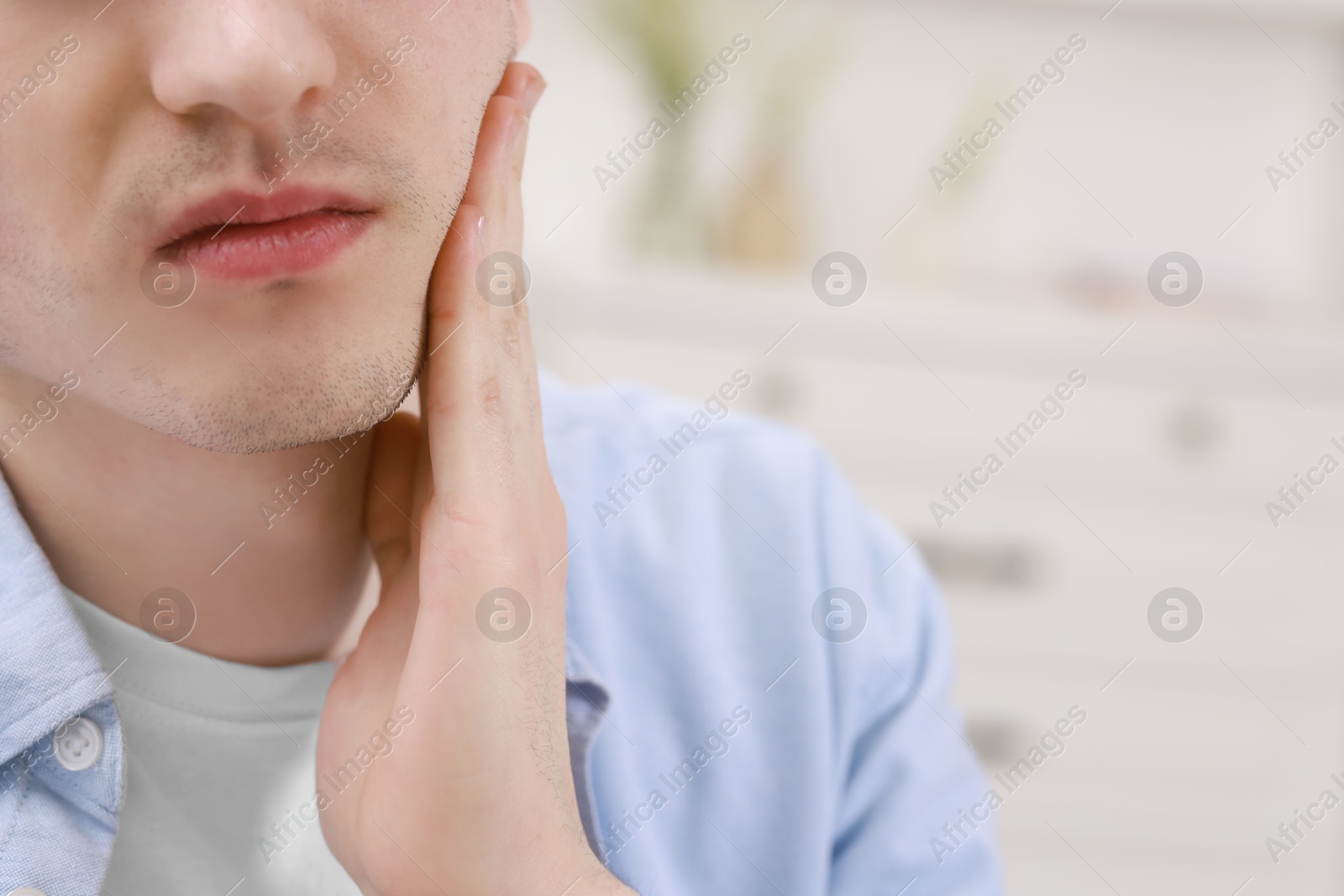 Photo of Man suffering from toothache at home, closeup. Space for text