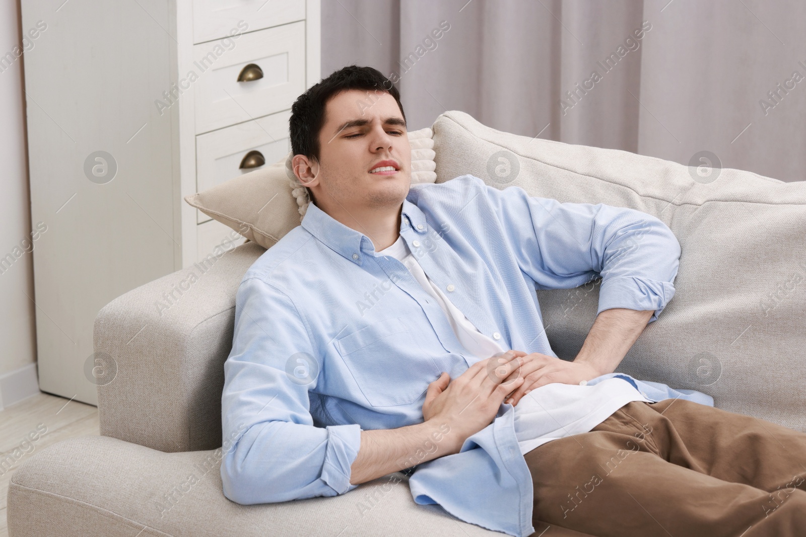 Photo of Man suffering from abdominal pain at home