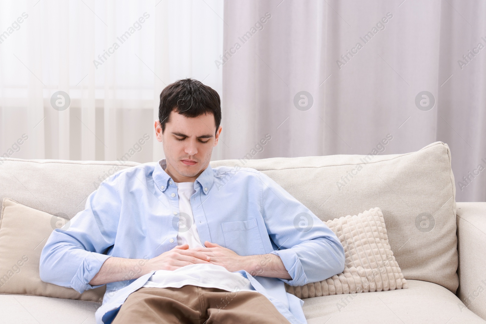 Photo of Man suffering from abdominal pain at home