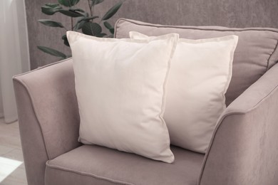 Photo of Soft pillows on grey armchair in room