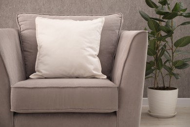 Photo of Soft pillows on grey armchair in room