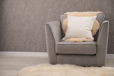 Photo of Soft pillows on armchair in living room. Space for text