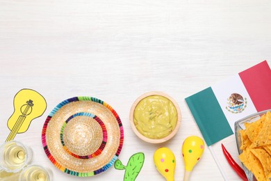 Mexican flag, maracas, tequila, nachos chips and sombrero hat on white wooden table, flat lay. Space for text