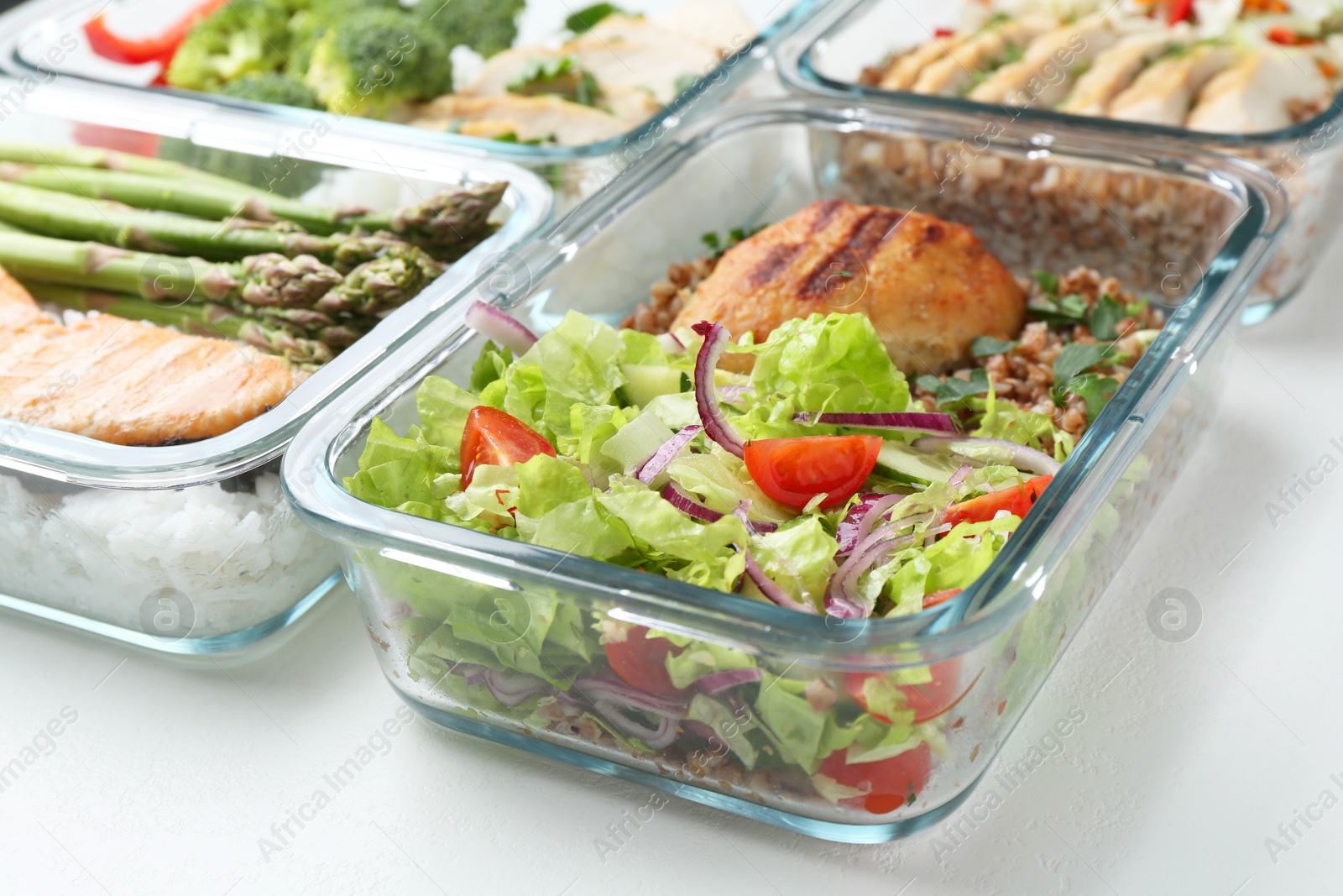 Photo of Healthy food. Different meals in glass containers on white background