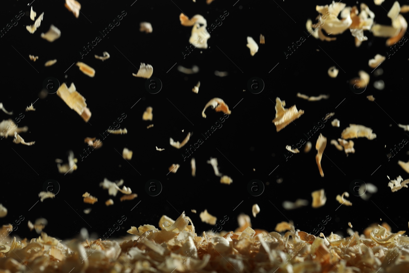 Photo of Dry natural sawdust falling on black background