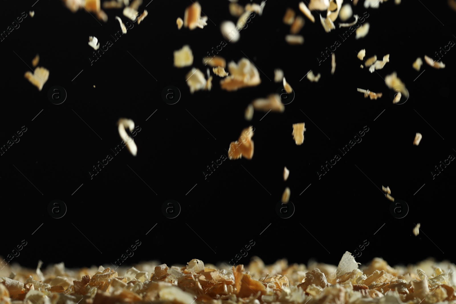 Photo of Dry natural sawdust falling on black background