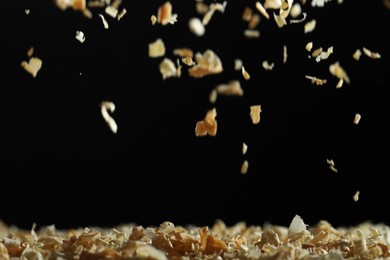 Photo of Dry natural sawdust falling on black background