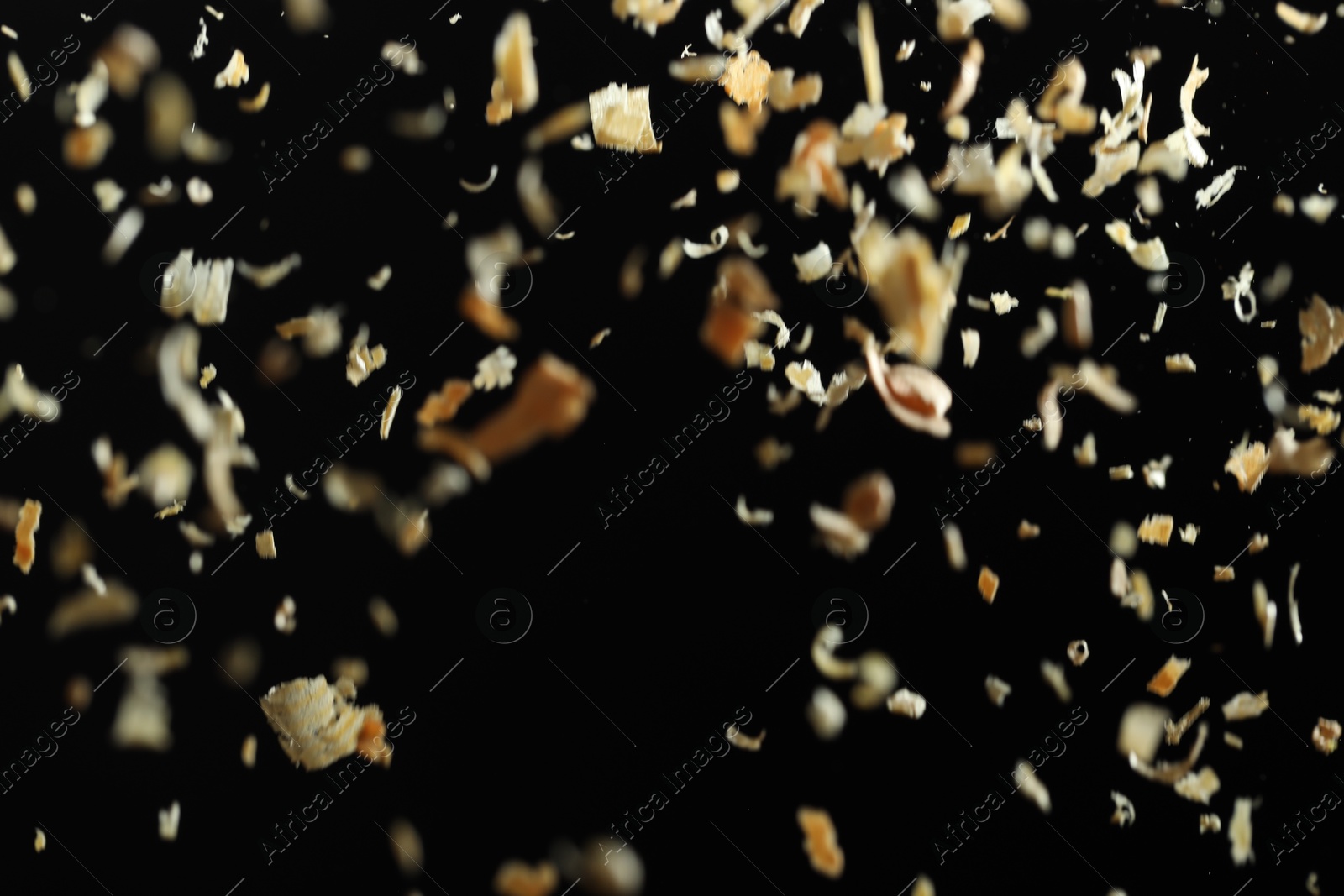 Photo of Dry natural sawdust falling on black background