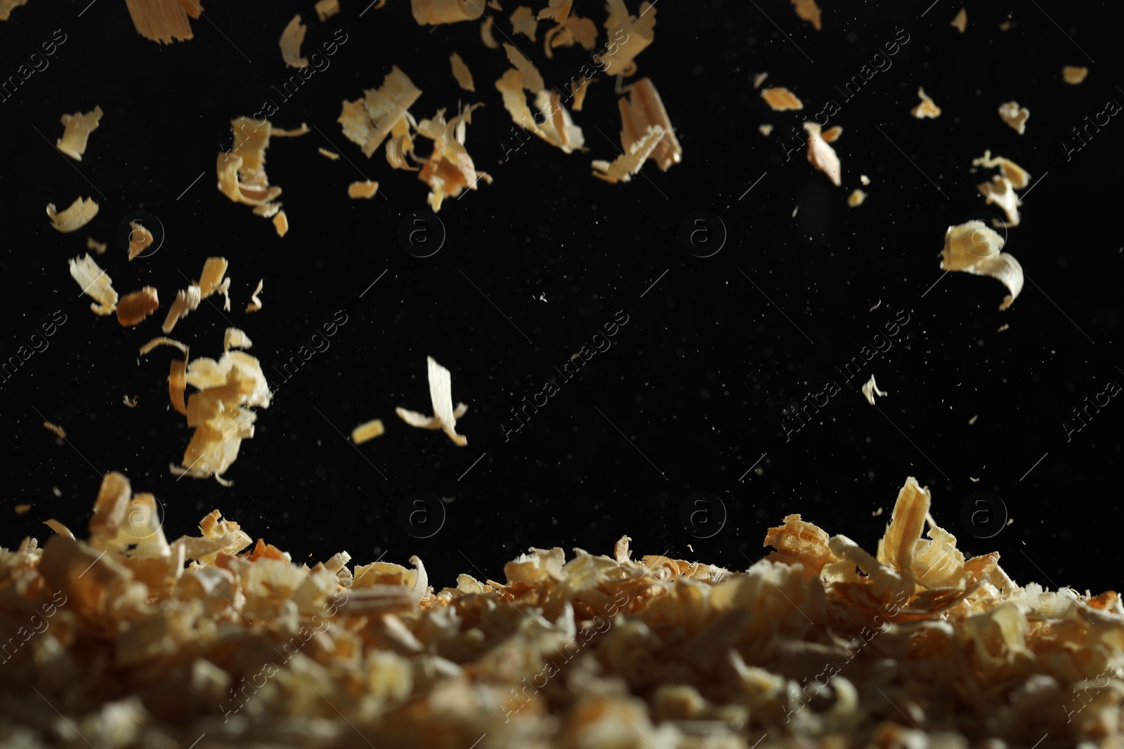 Photo of Dry natural sawdust falling on black background