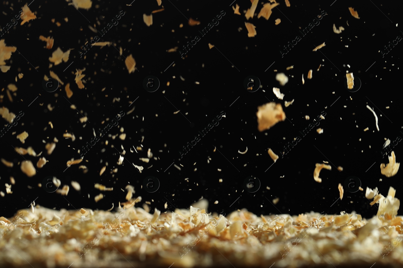 Photo of Dry natural sawdust falling on black background