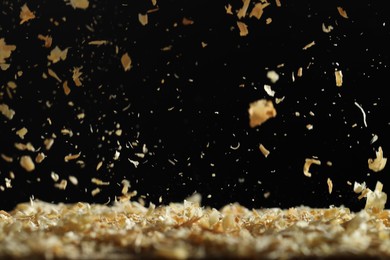 Photo of Dry natural sawdust falling on black background