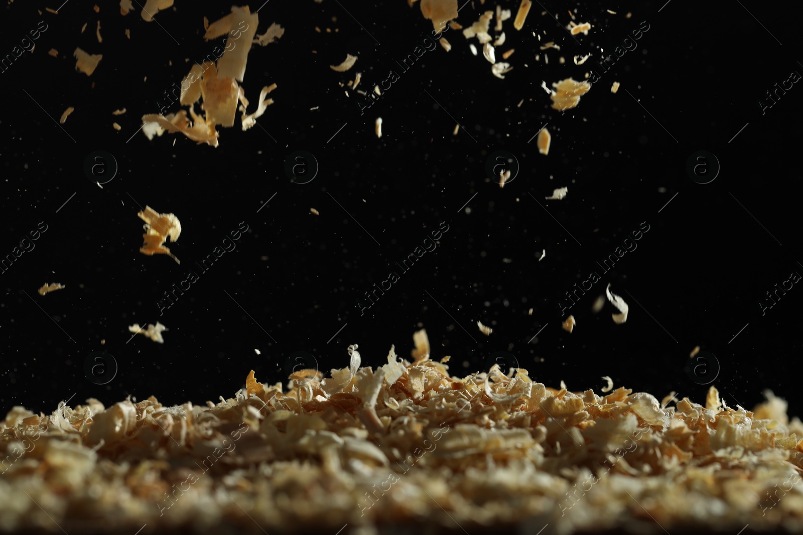 Photo of Dry natural sawdust falling on black background