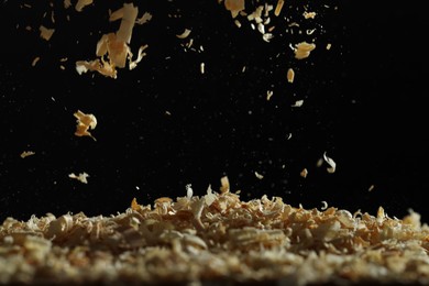 Photo of Dry natural sawdust falling on black background