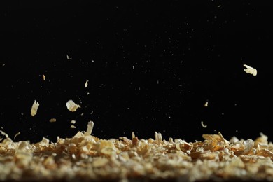 Photo of Dry natural sawdust falling on black background
