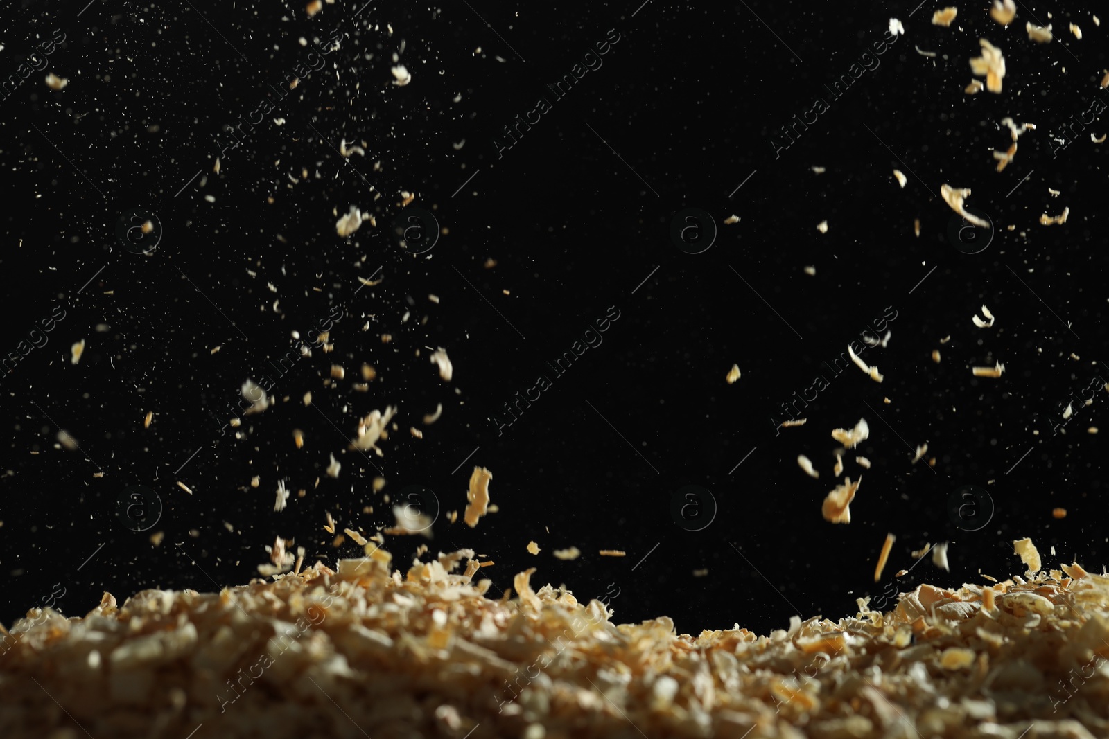 Photo of Dry natural sawdust falling on black background