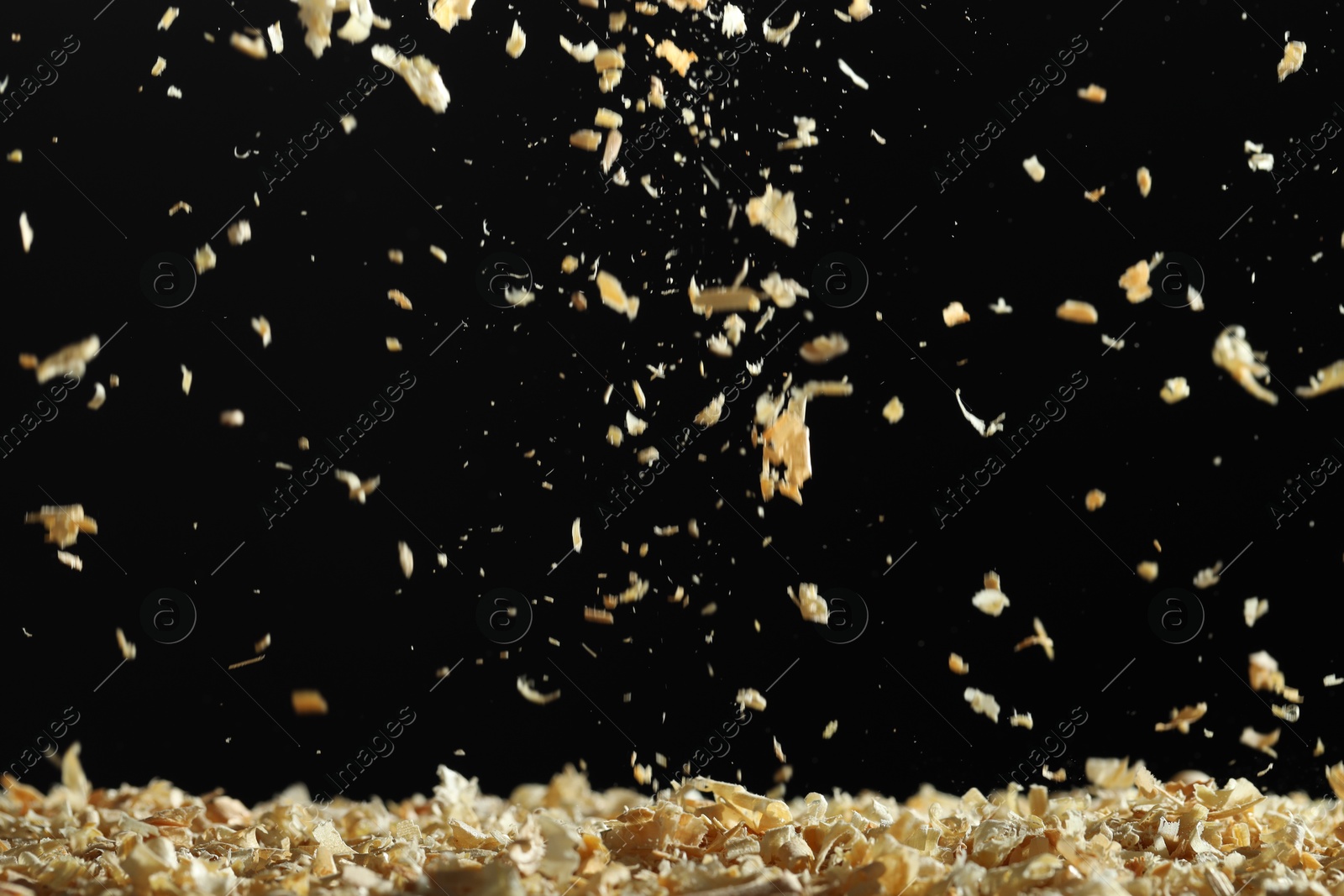 Photo of Dry natural sawdust falling on black background