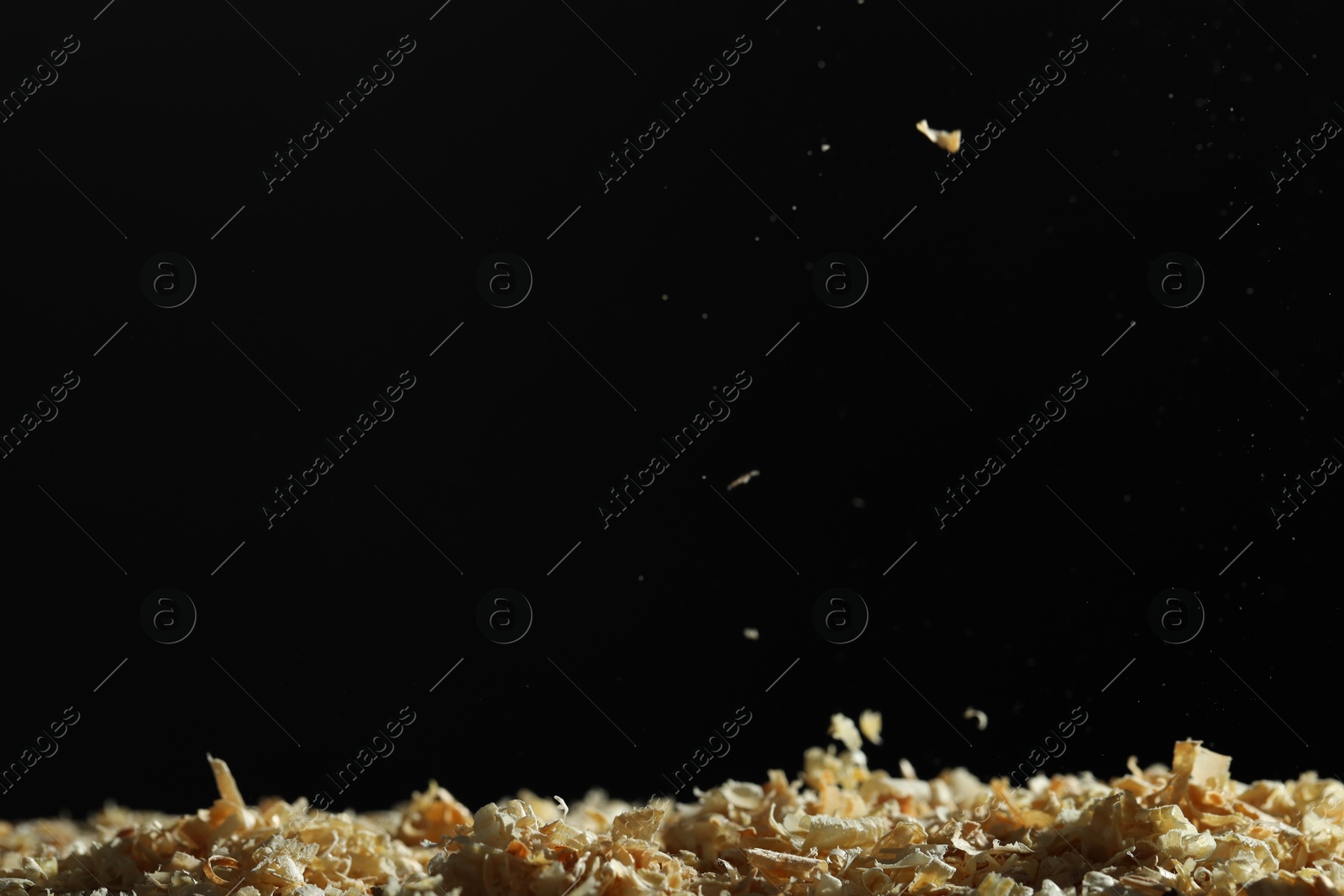 Photo of Dry natural sawdust on black background, space for text