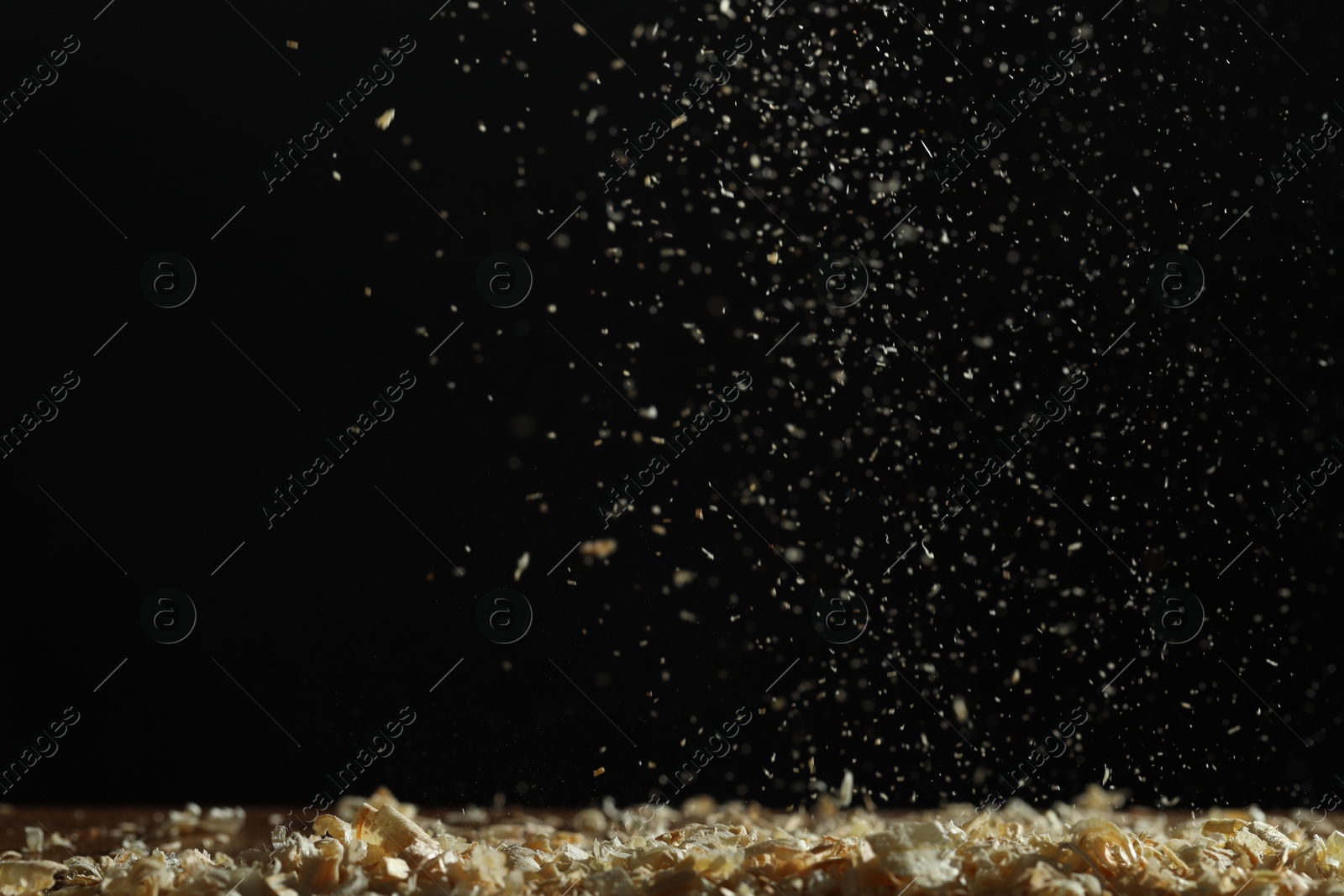 Photo of Dry natural sawdust falling on black background