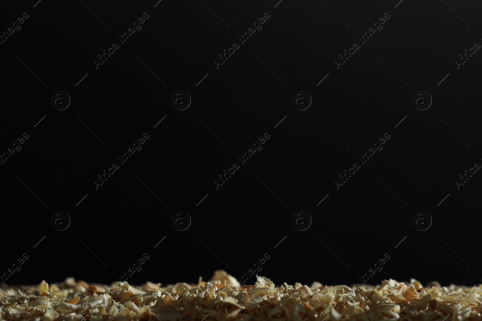 Photo of Dry natural sawdust on black background, space for text