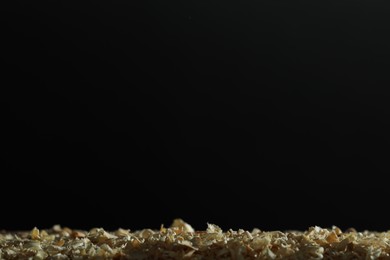 Photo of Dry natural sawdust on black background, space for text