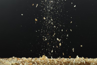 Dry natural sawdust falling on black background
