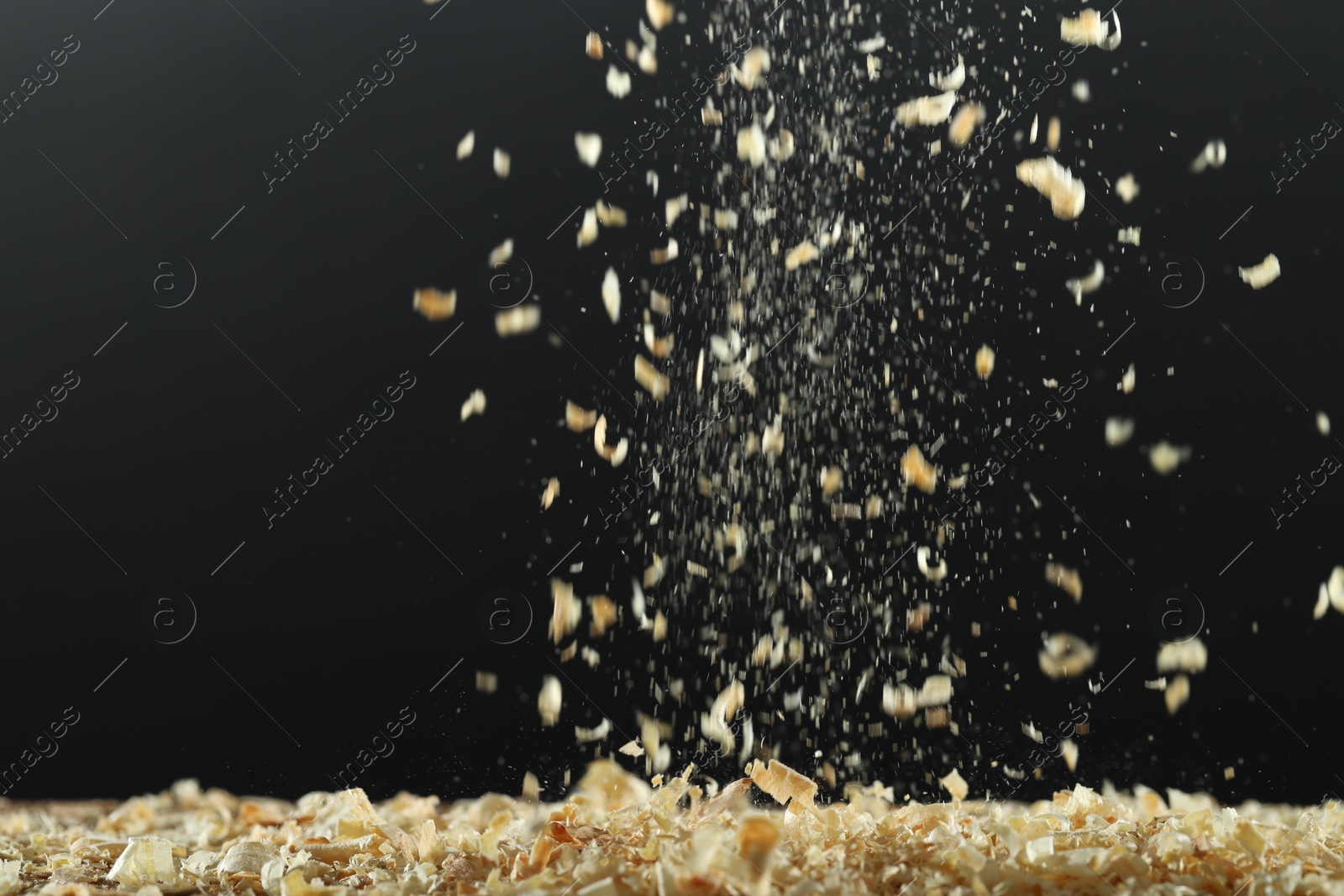 Photo of Dry natural sawdust falling on black background