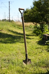 One shovel sticking out of ground on sunny day. Gardening season