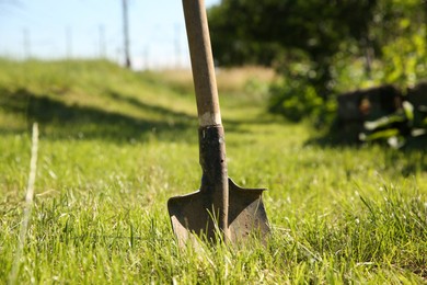 Photo of One shovel sticking out of ground on sunny day. Gardening season