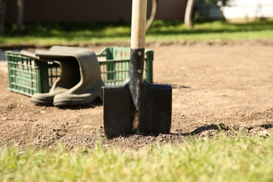 Photo of One shovel sticking out of ground on sunny day. Gardening season