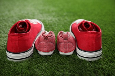 Big and small shoes on green grass