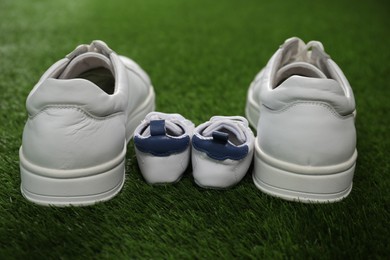 Photo of Big and small shoes on green grass