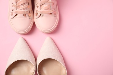 Big and small shoes on pink background, top view. Space for text