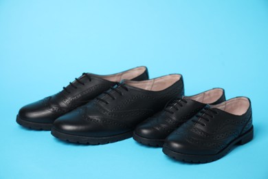 Big and small shoes on light blue background