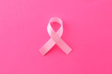 Photo of Awareness ribbon on pink background, top view