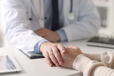 Professional doctor working with patient at white table in hospital, closeup