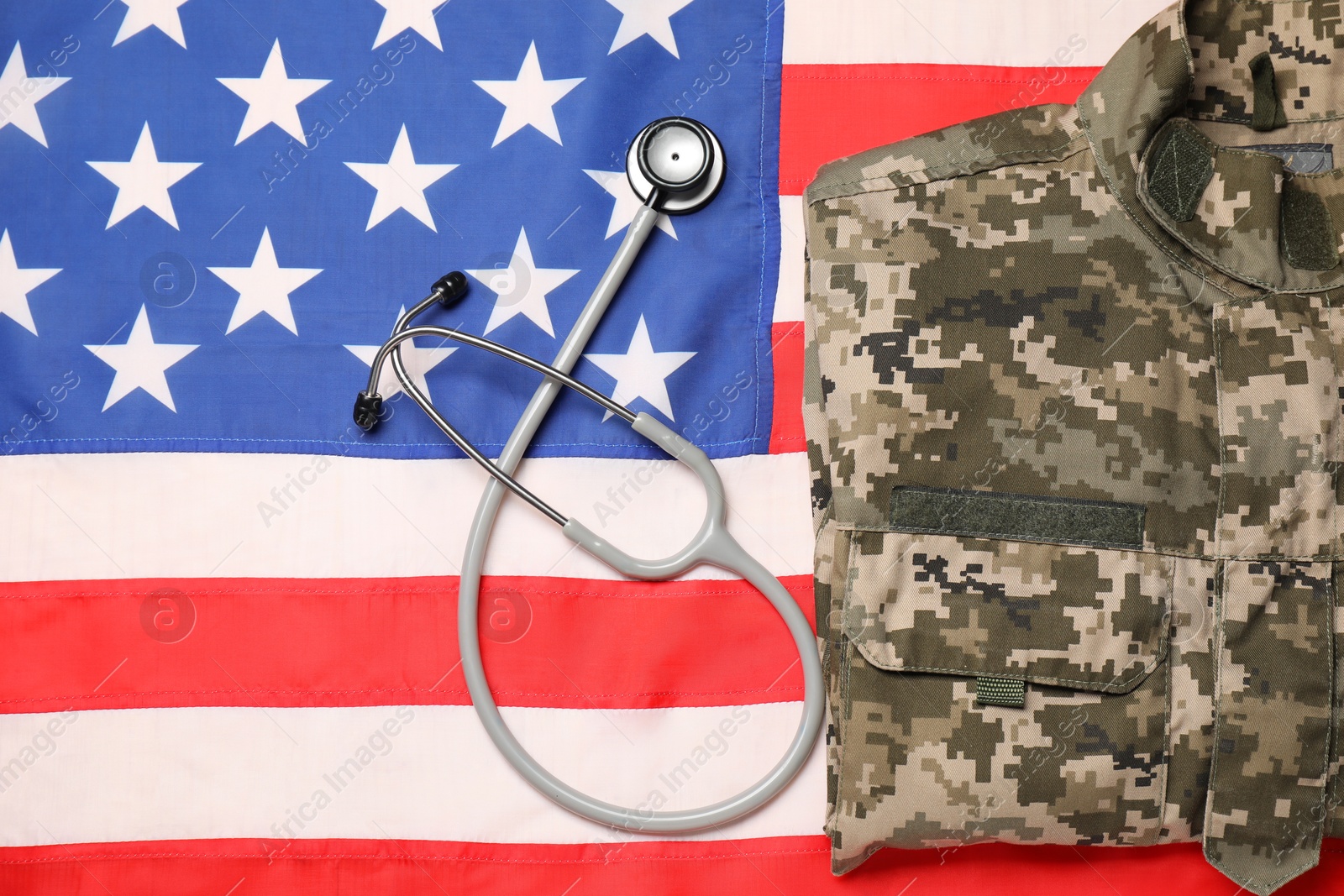 Photo of Stethoscope and military uniform on USA flag, top view