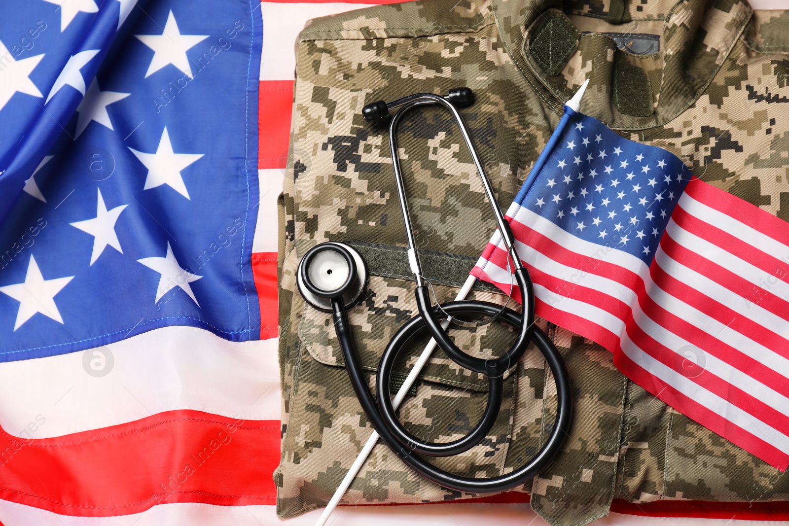 Photo of Stethoscope and military uniform on USA flag, top view