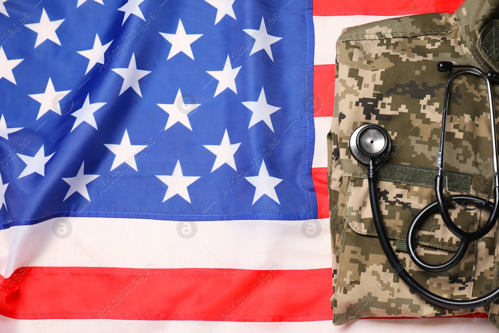 Photo of Stethoscope and military uniform on USA flag, top view