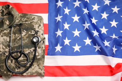 Stethoscope and military uniform on USA flag, top view