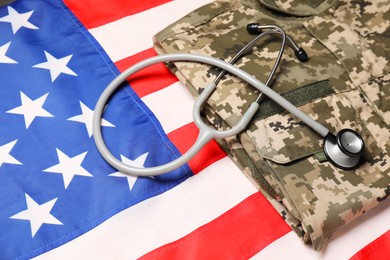 Photo of Stethoscope and military uniform on USA flag, closeup