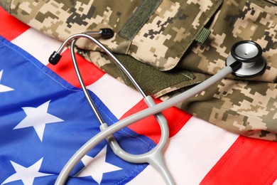 Photo of Stethoscope and military uniform on USA flag, closeup